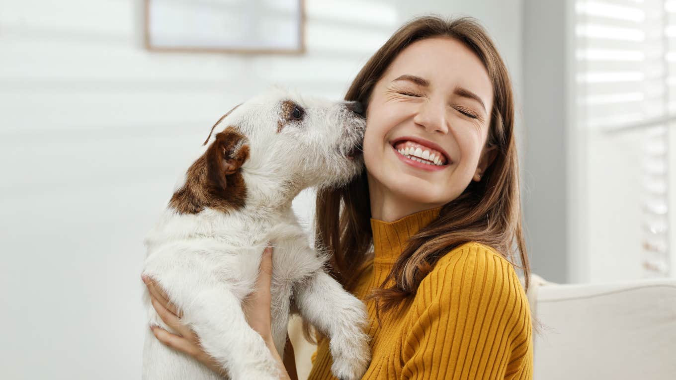 Woman holding her dog and smiling