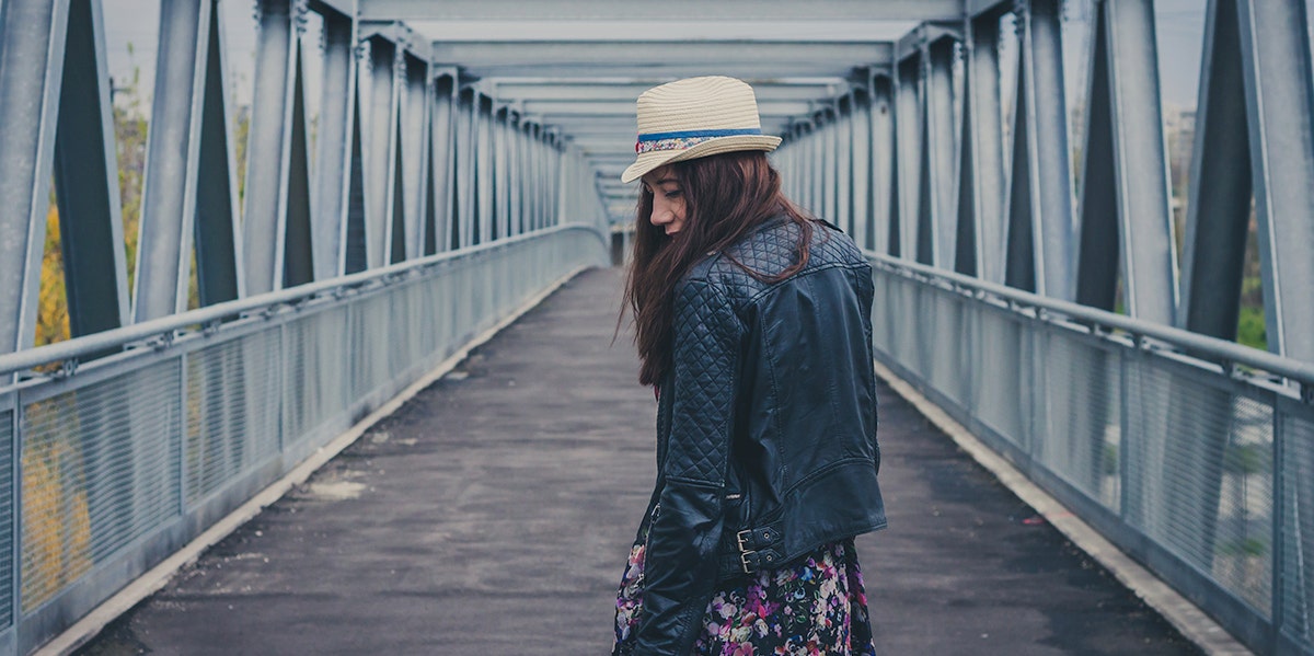 woman on a bridge walking away