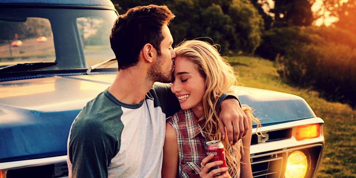 couple kissing lovingly by vintage truck