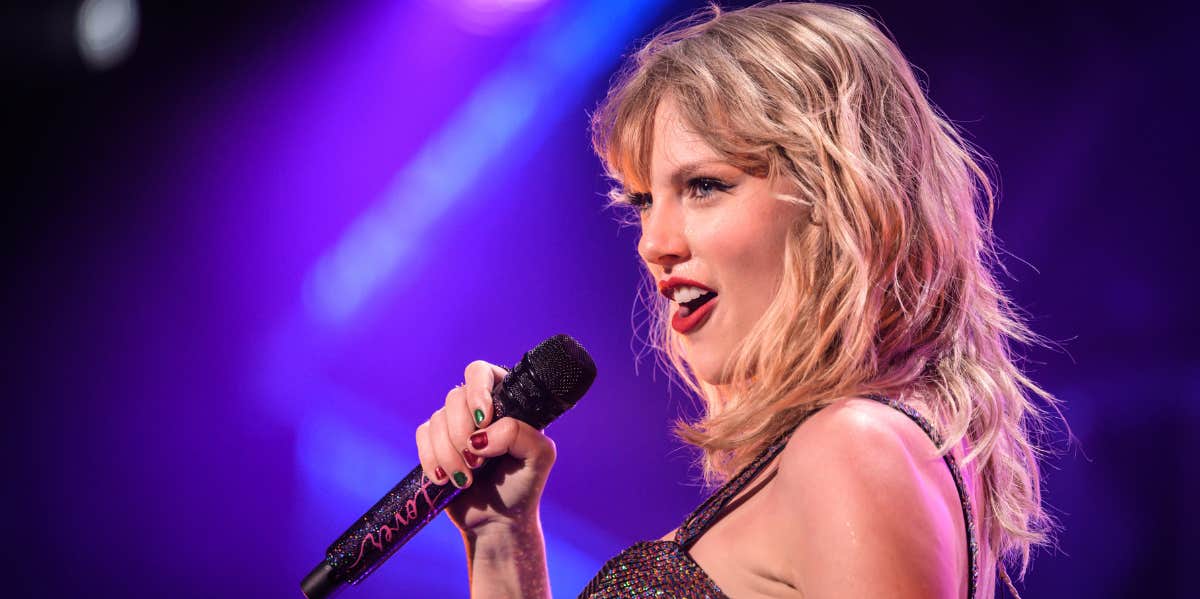 Taylor Swift’s Blackmail Tactic To Get Good Reviews Taylor Swift’s Blackmail Tactic To Get Good Reviews. Taylor Swift performing on state, singing into a mic