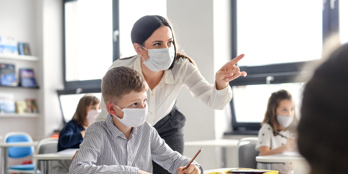 Teacher and children with face mask 