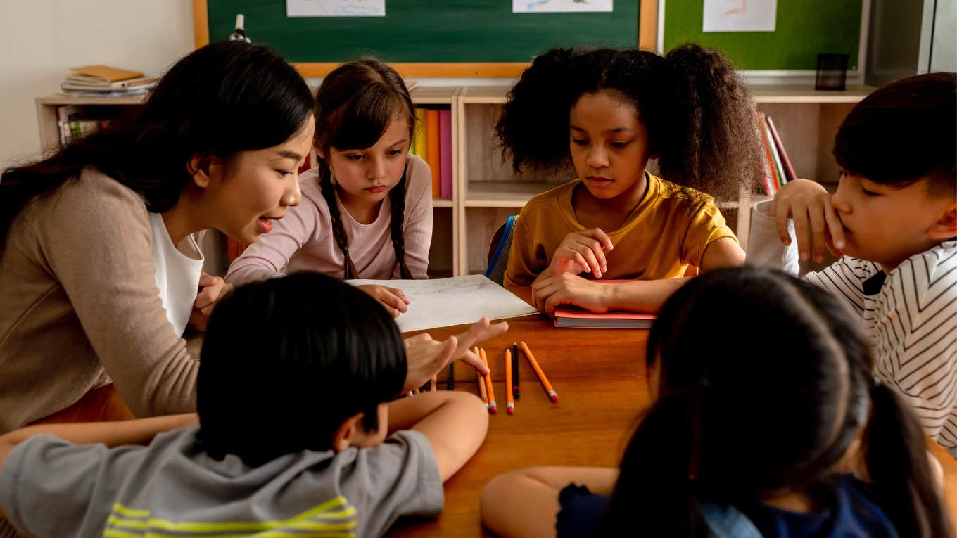 Teacher sitting with her little students. 