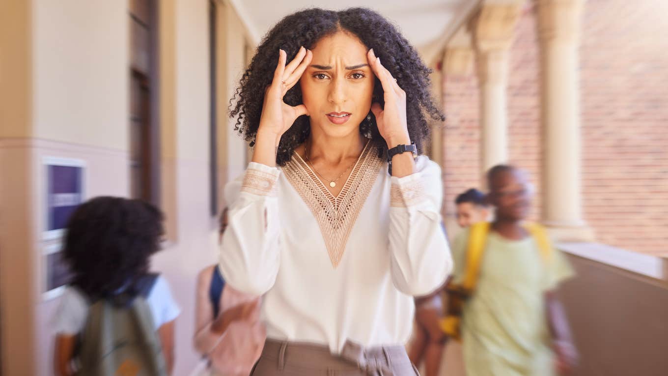 frustrated teacher in the midst of students walking down the hallway