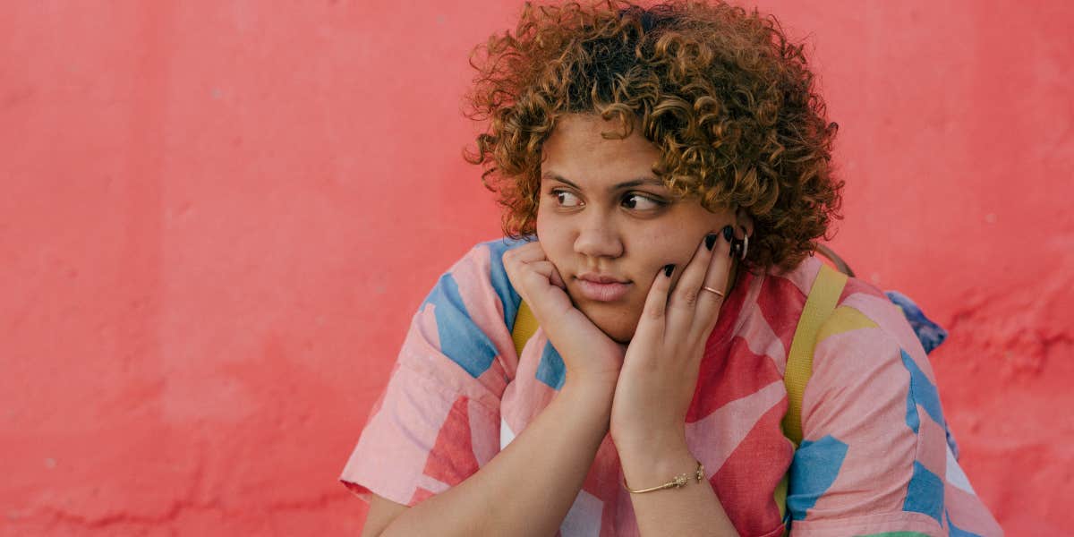 Teen with striped shirt in front of a pink wall