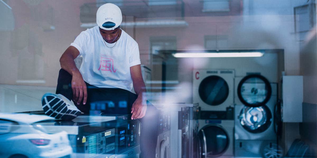 young man sitting in laundromat