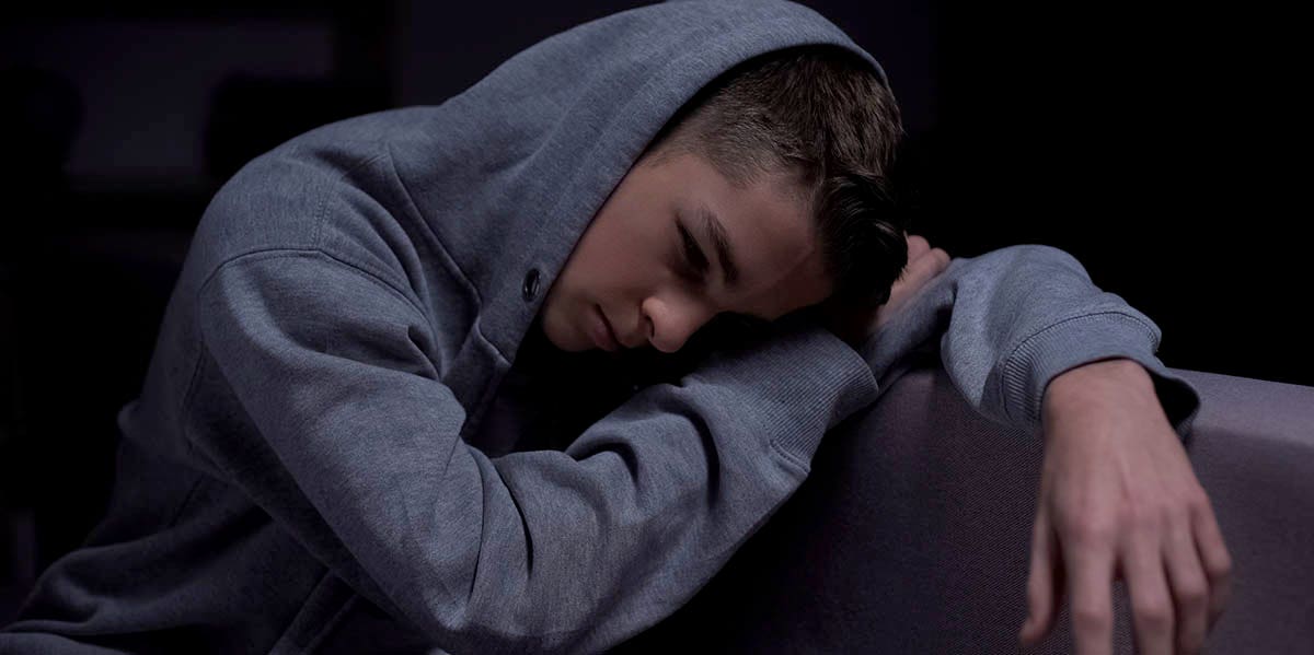 moody photo of teenager in hoody