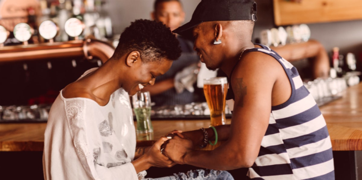 woman and man at bar holding hands