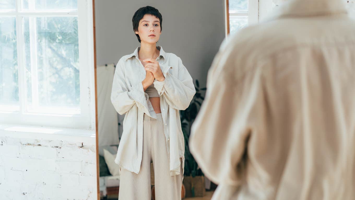 Woman looking at herself in the mirror. 