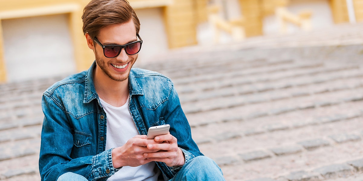 man in suit jacket texting on phone