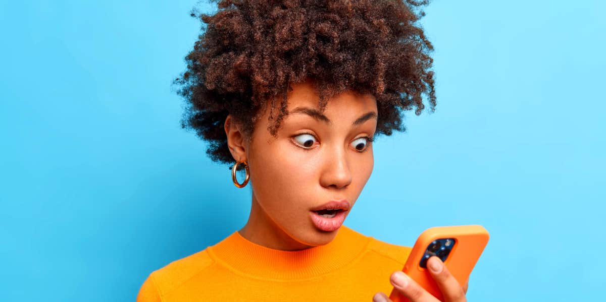 woman looking at her phone shocked by texts