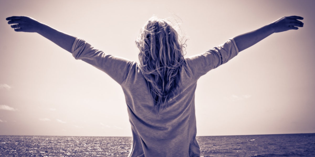 woman at beach with arms out