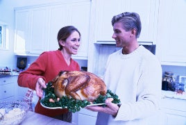 Why We Don't Visit Family During The Holidays couple cooking the thanksgiving turkey