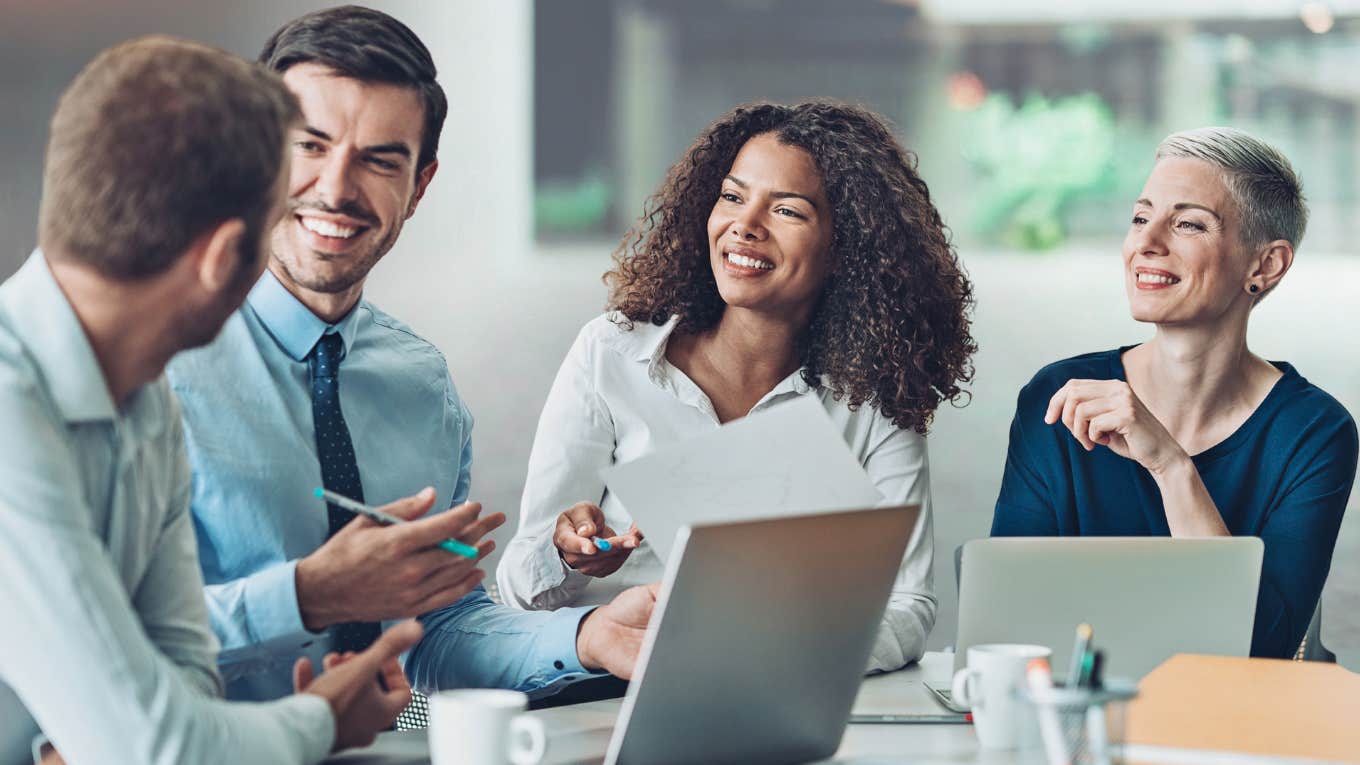 The 5 Things Great Managers Actually Do All Day Manager sits with their employees at a table.