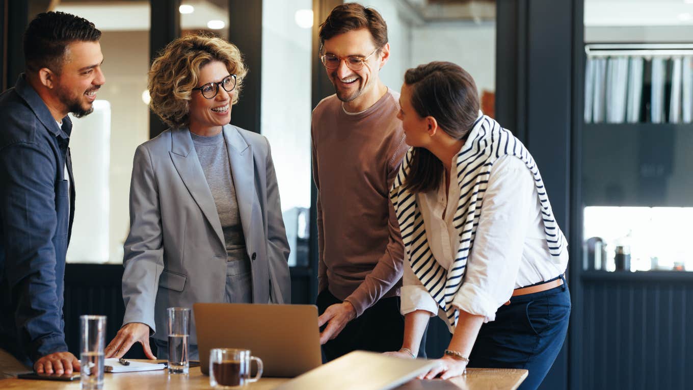 group of co-workers talking around computer