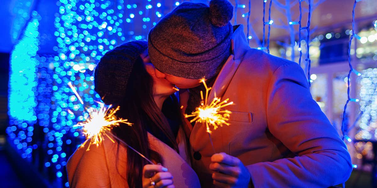 couple kissing holding sparklers on new years