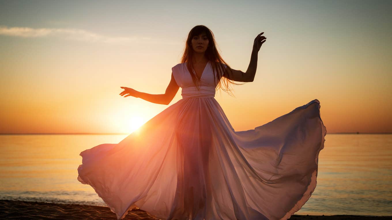 woman at sunset on beach in white dress
