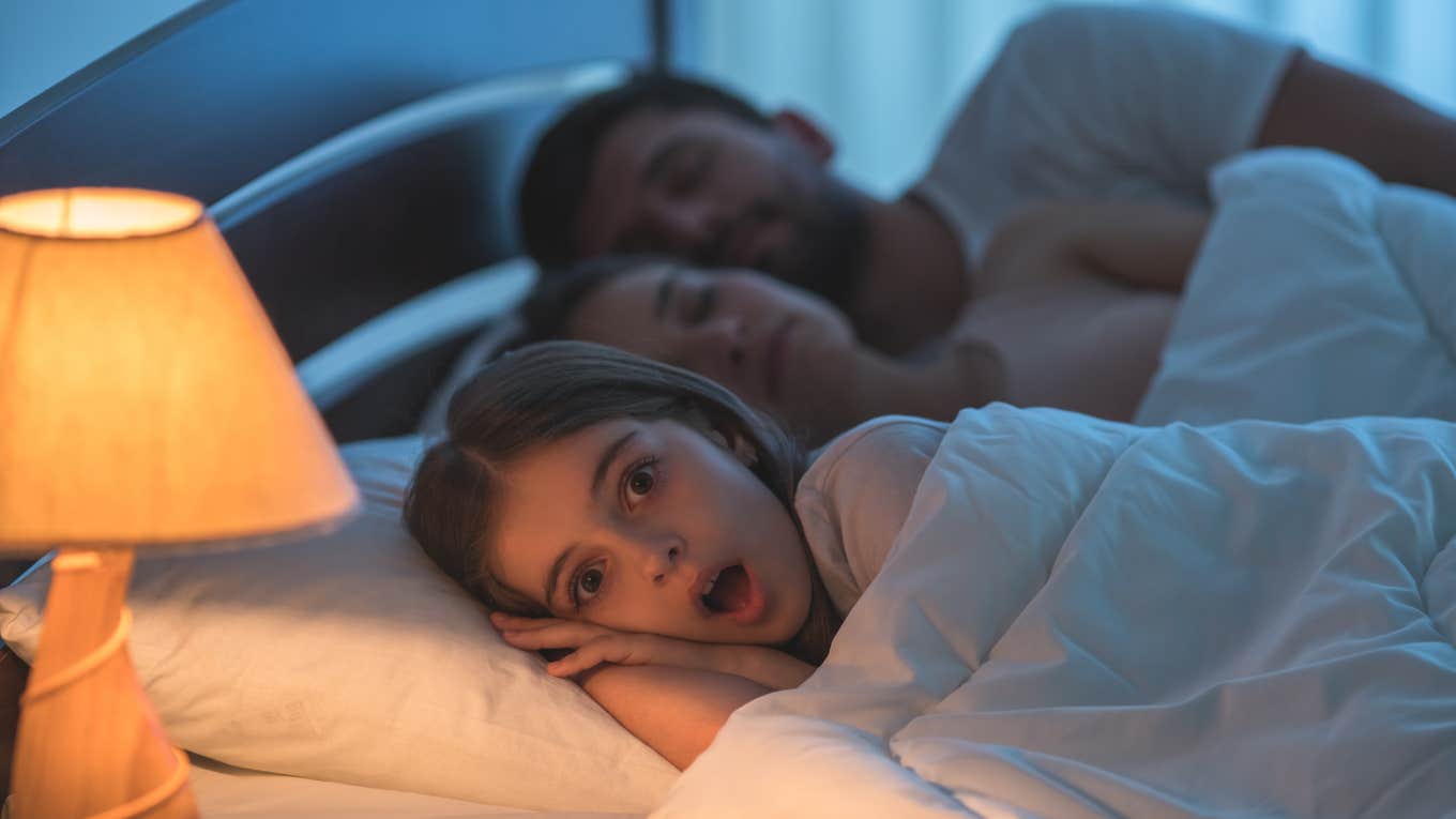 couple in bed with their child