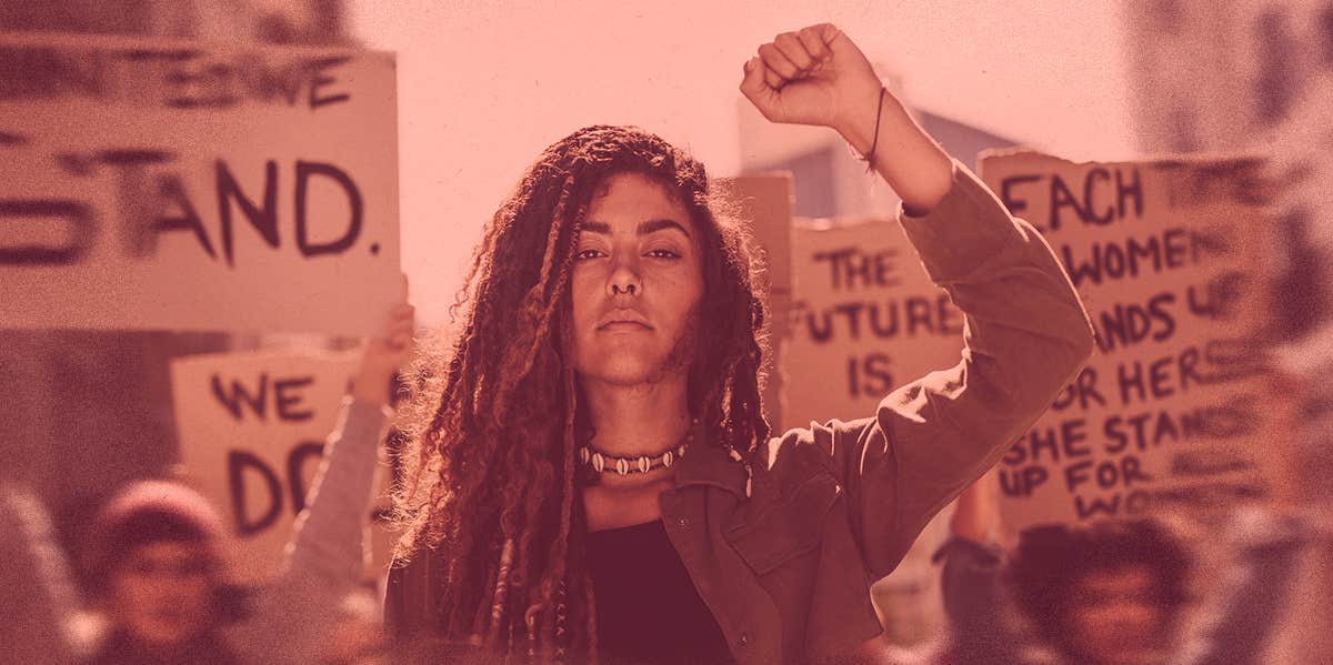 woman marching, raising hand