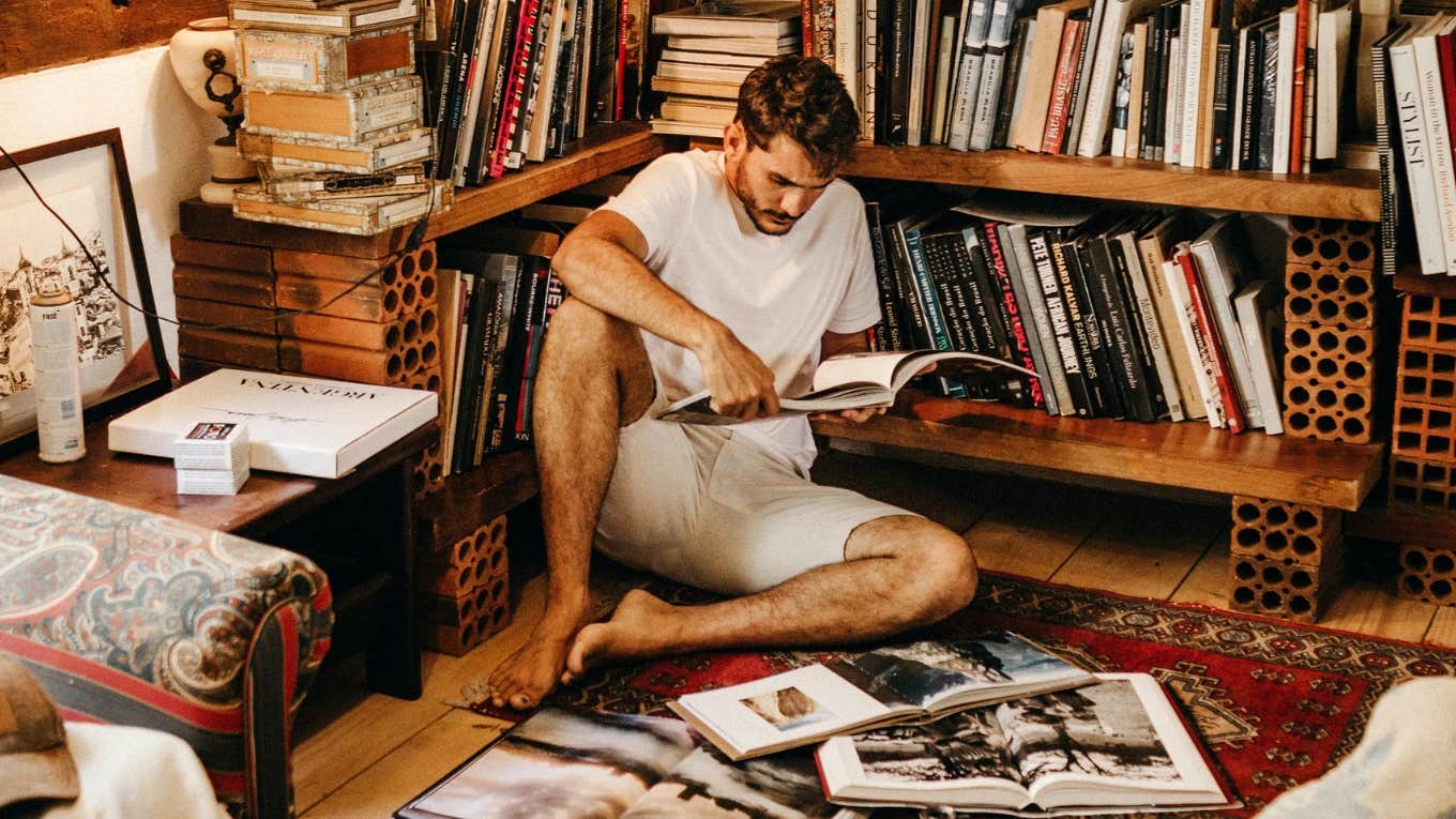 man reading surrounded by books