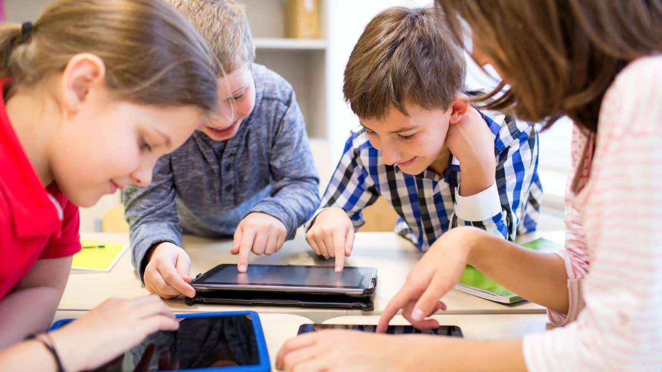 Therapist Explains How Technology In Schools Harms Kids' Brains & Could Be Impairing Their Ability To Learn kids on tablets at school