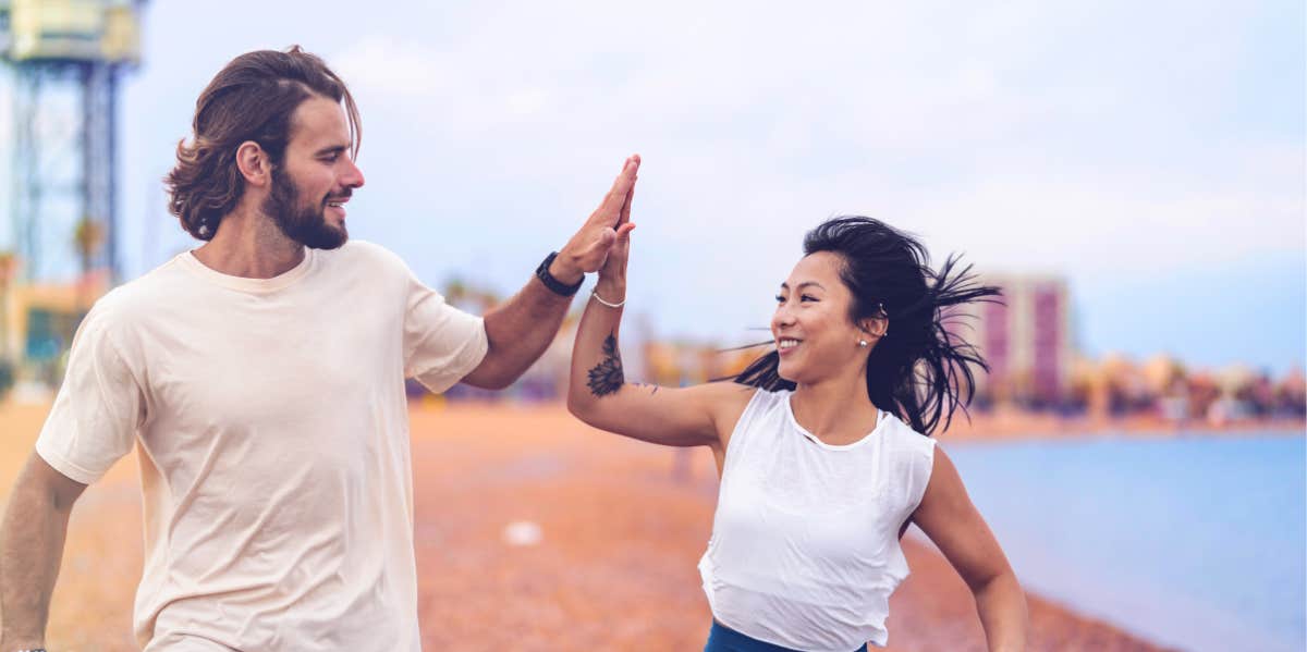 couple high fiving on the beach