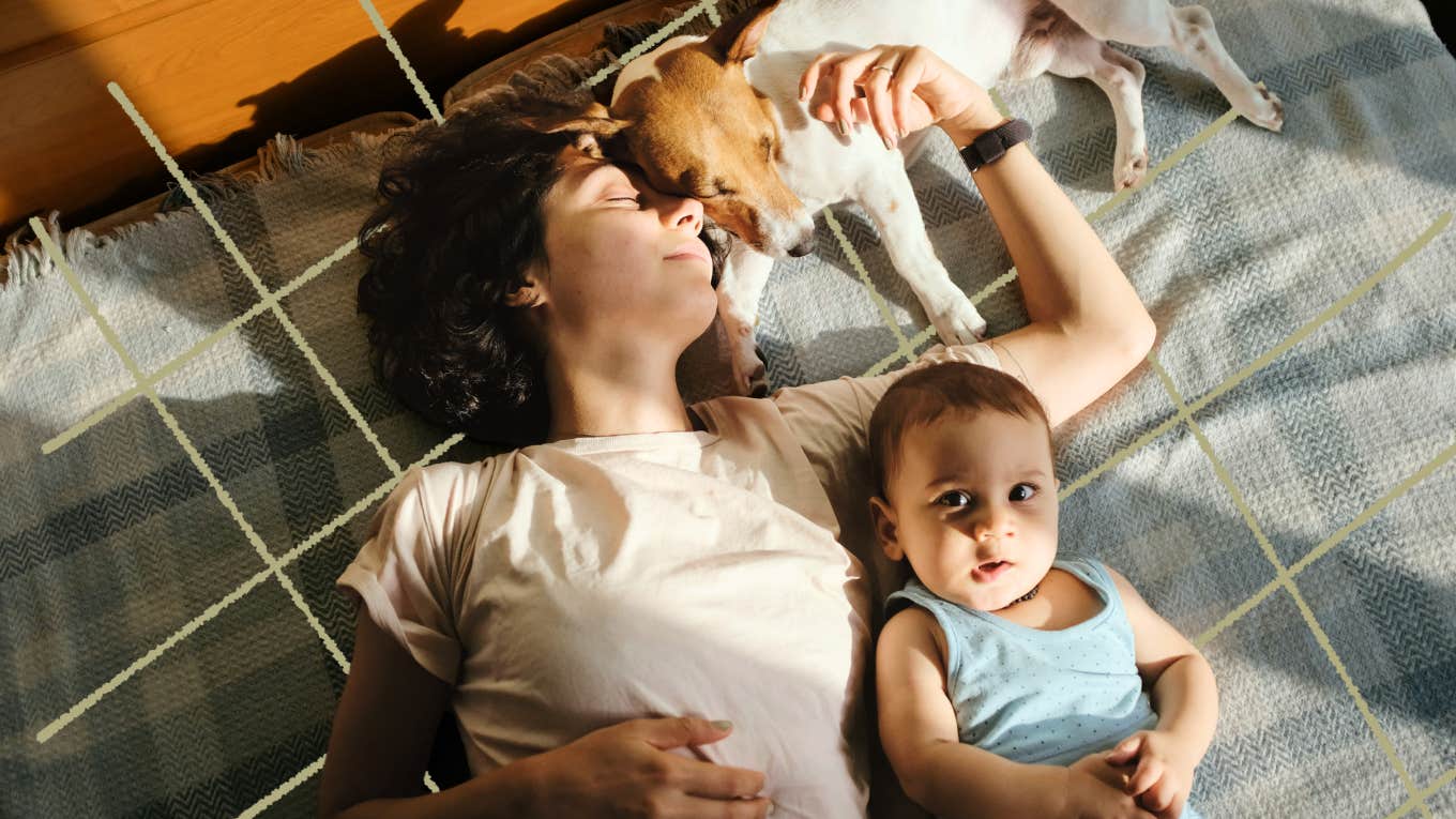 mom laying dow with her baby and dog