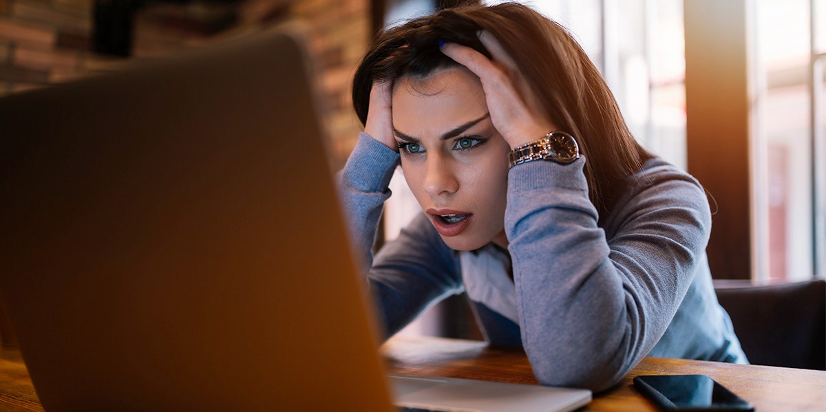 My Online Date Turned Out To Be A Cold, Hard Thief woman with her head in her hands looking at computer screen
