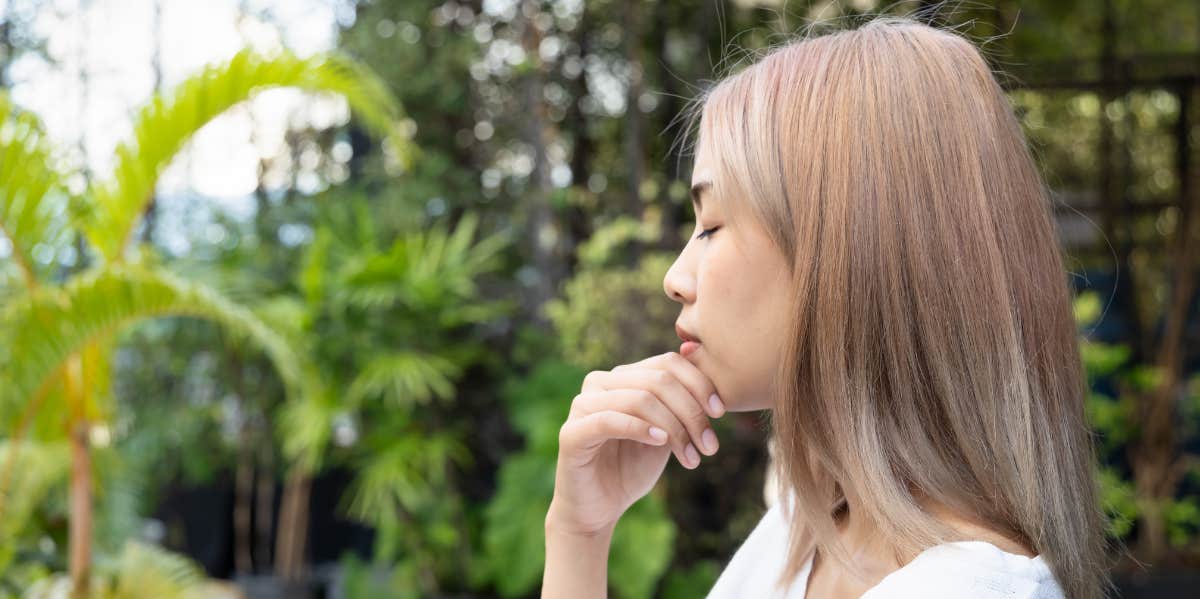 woman side profile next to tree