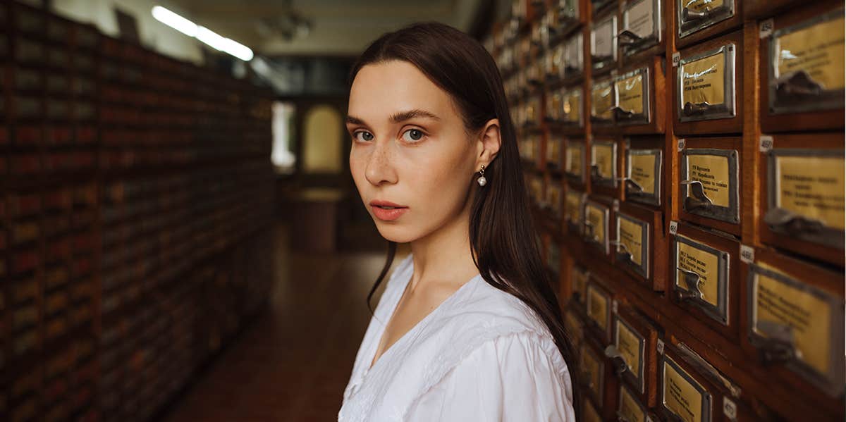 woman standing in library with serious expression