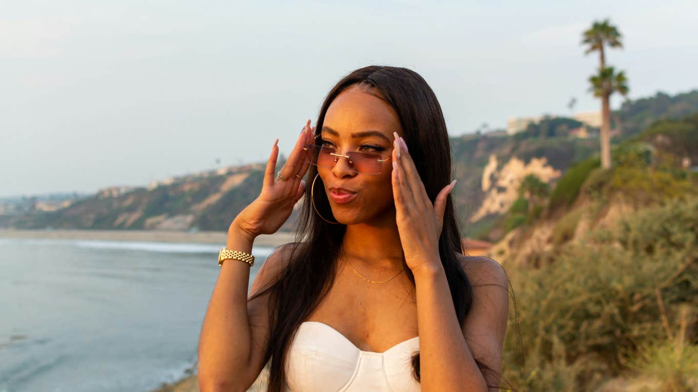 woman putting sunglasses on during golden hour