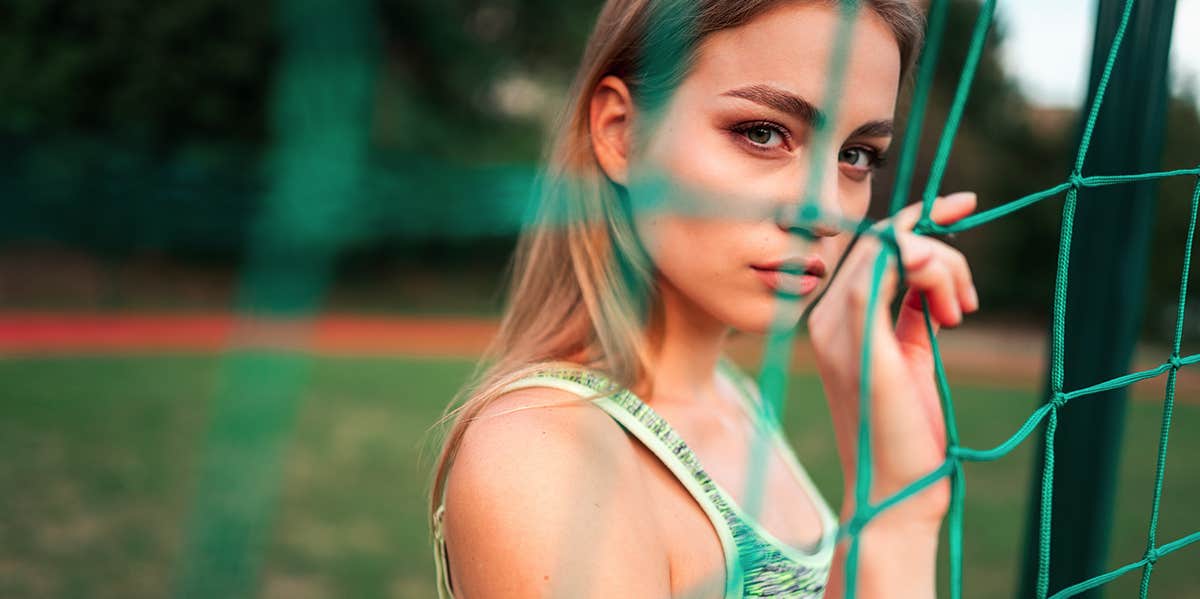 woman peering through soccer net