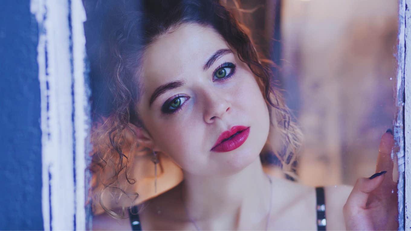 anxious woman looking through window