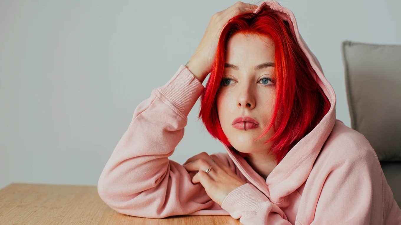 sad woman with red hair thinking