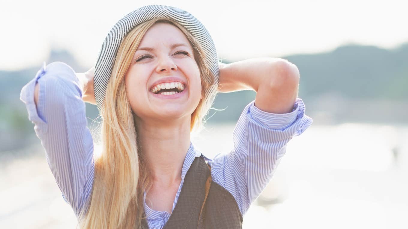 young blonde woman smiling in hat