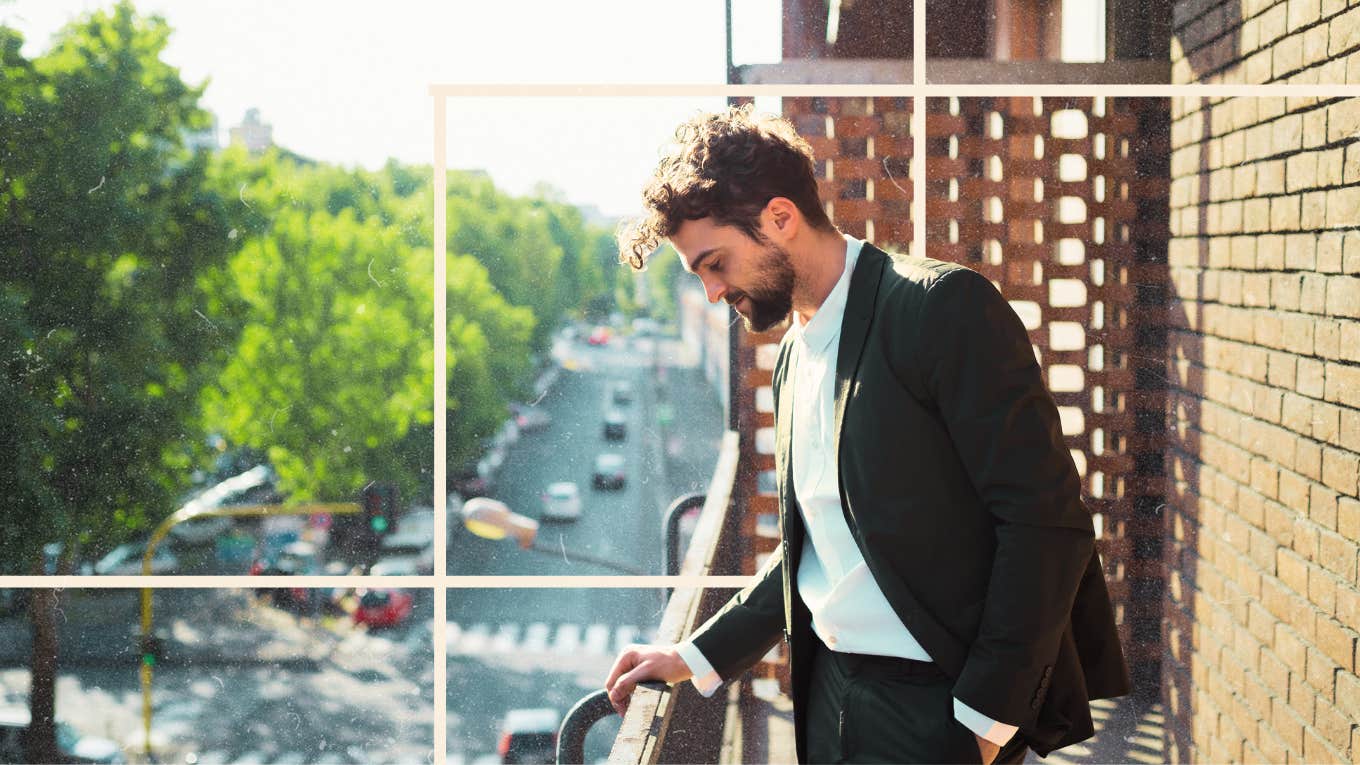 Man with head down holding rail on balcony