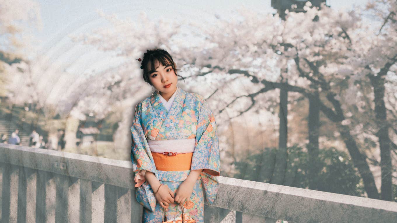 Japanese woman in front of cherry blossoms 