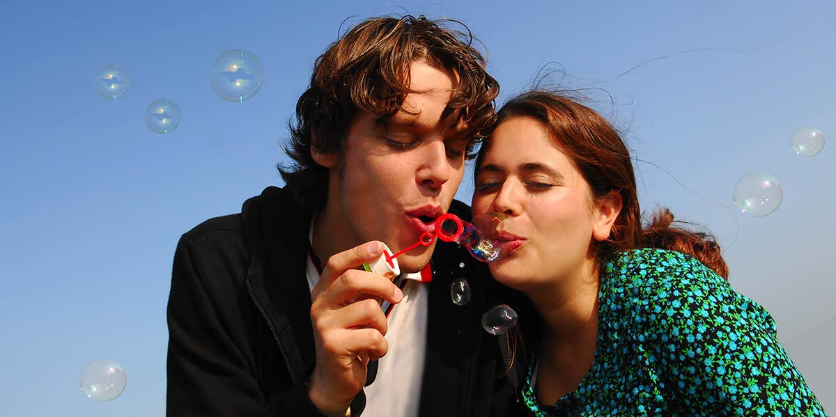 man and woman blowing bubbles