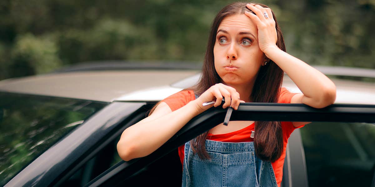 woman looking distraught with car door open
