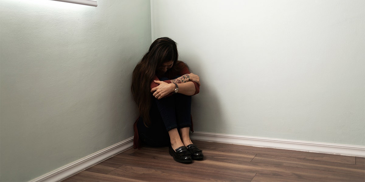 woman sitting in corner