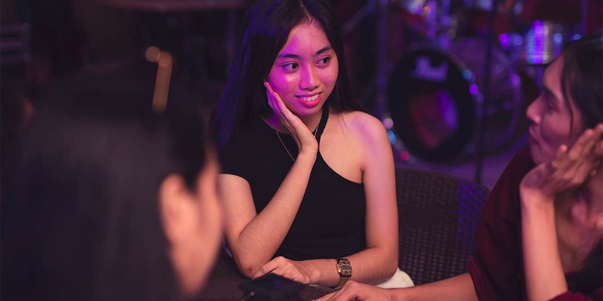 woman at dinner with friends listening to them talk