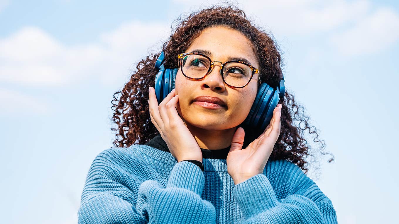 girl outside listening to headphones