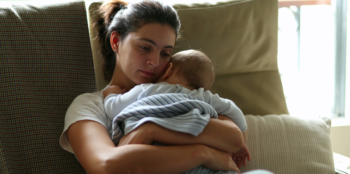 exhausted mother holding baby