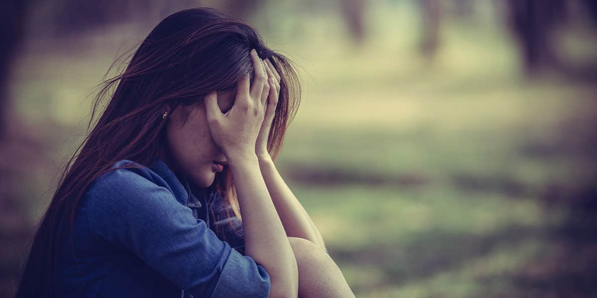 woman upset covering face