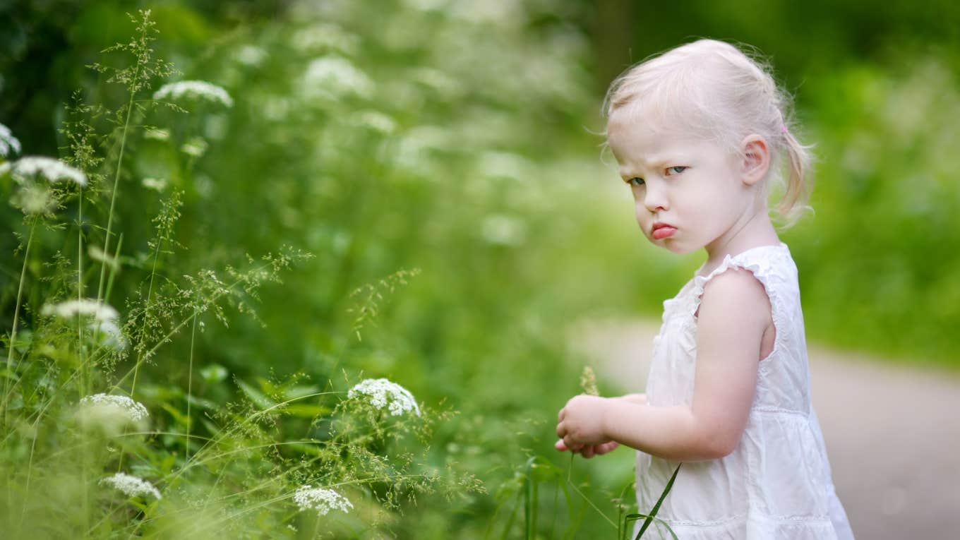 angry toddler girl picking flowers