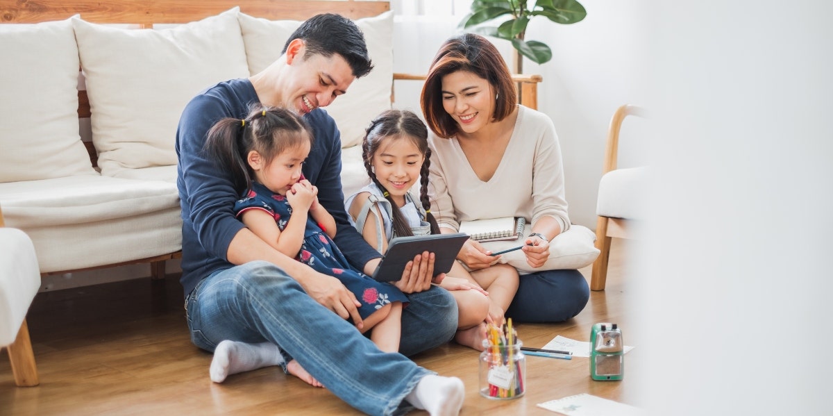 family of four looking at ipad