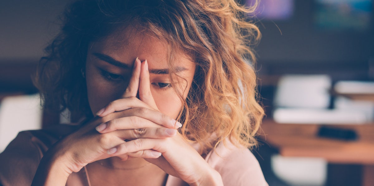 woman with head on hands sad upset crying