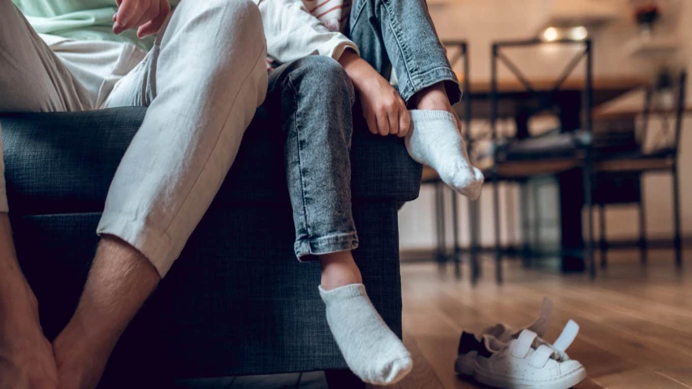 man and younger boy putting on socks and shoes