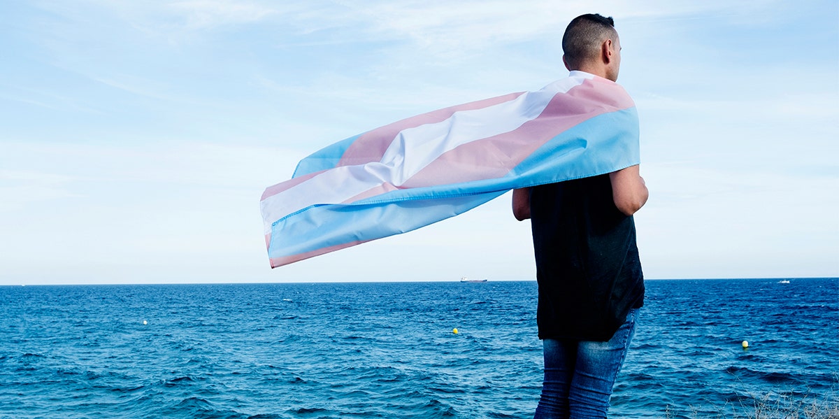 man standing near lake with flag