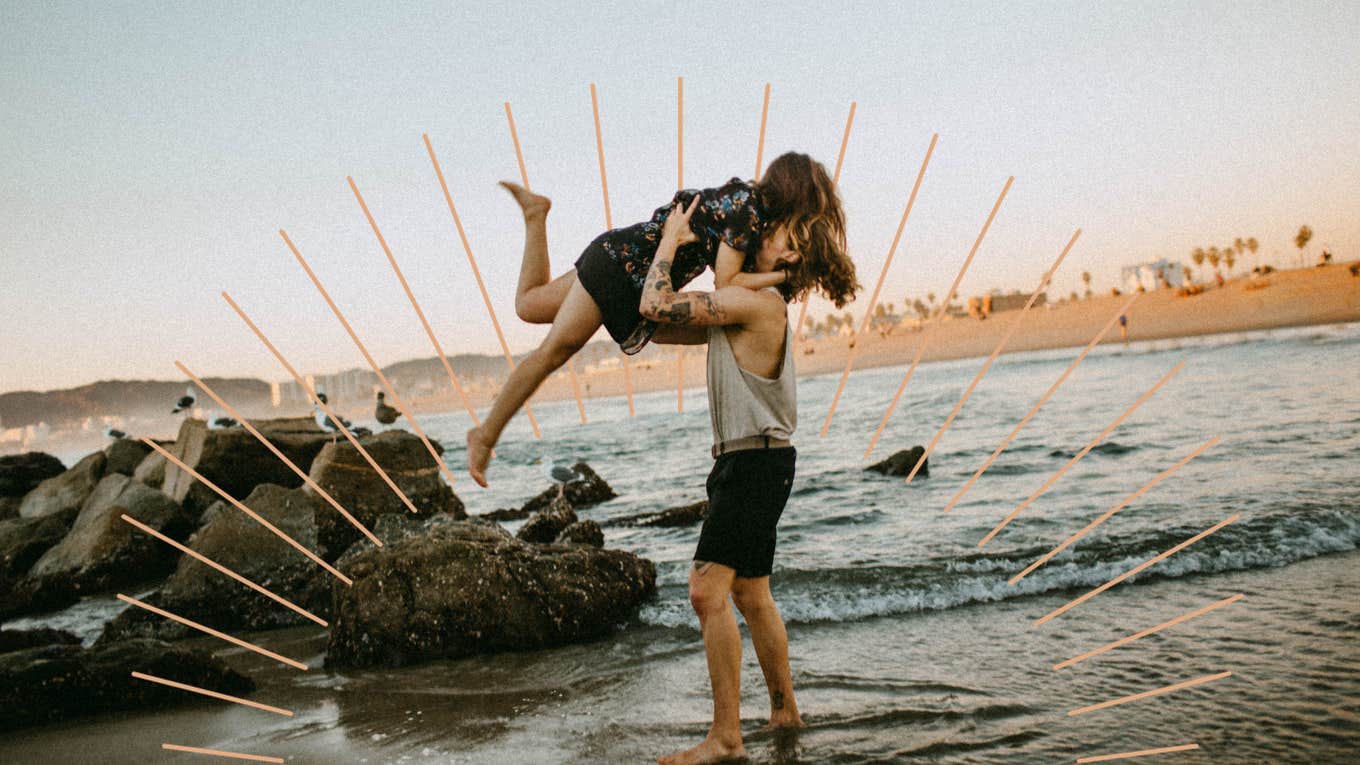 Couple on the beach together, man swinging woman in the air