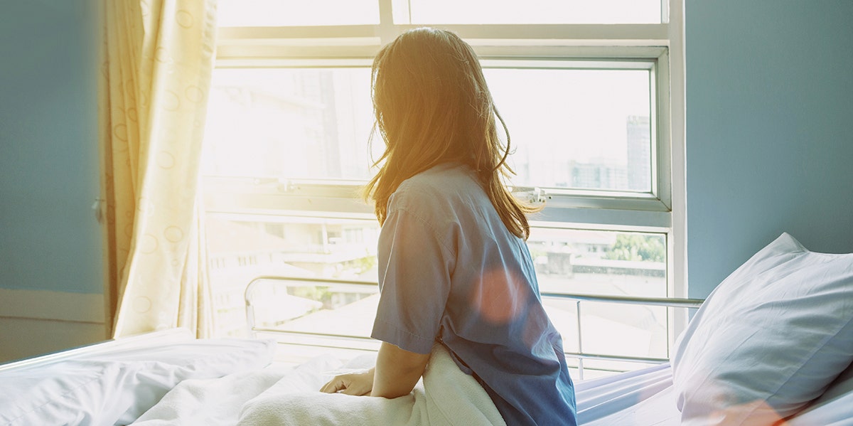 woman sitting on bed bathed in sunlight